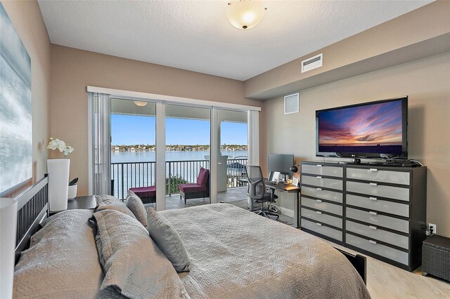 bedroom featuring access to exterior and a textured ceiling