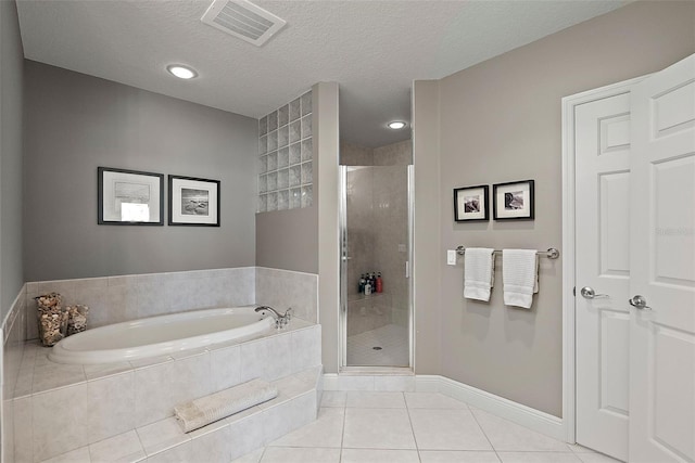 bathroom featuring tile patterned floors, independent shower and bath, and a textured ceiling