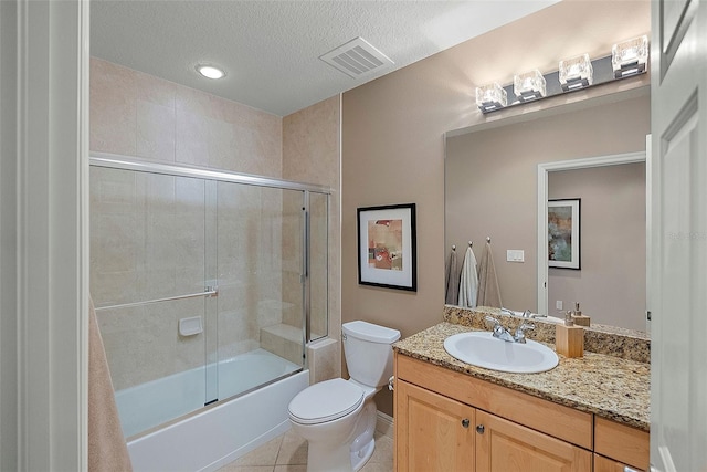 full bathroom with vanity, tile patterned floors, toilet, enclosed tub / shower combo, and a textured ceiling