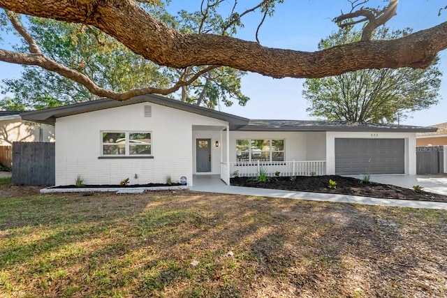 ranch-style house with a porch, a garage, and a front yard