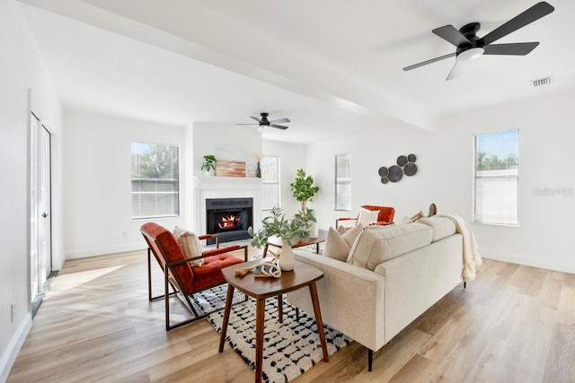 living room with beamed ceiling, ceiling fan, and light hardwood / wood-style floors