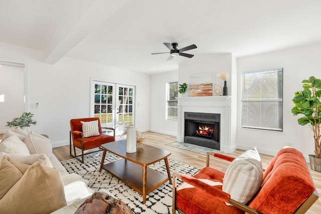 living room with beam ceiling, french doors, ceiling fan, and light wood-type flooring