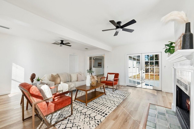 living room featuring french doors, ceiling fan, and light hardwood / wood-style flooring