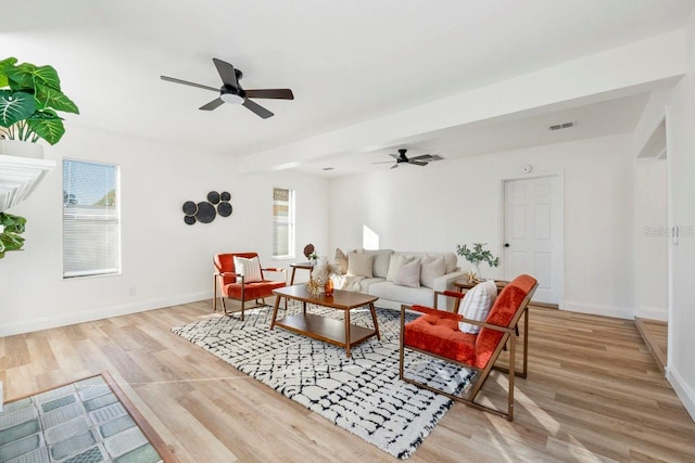 living room featuring plenty of natural light, ceiling fan, and light hardwood / wood-style flooring