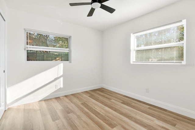 empty room featuring ceiling fan, plenty of natural light, and light hardwood / wood-style floors