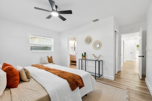 bedroom with ensuite bathroom, a closet, ceiling fan, and light hardwood / wood-style floors