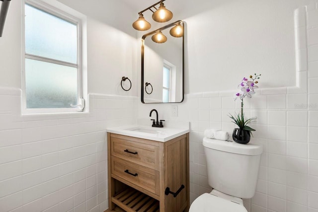 bathroom with vanity, tile walls, and toilet