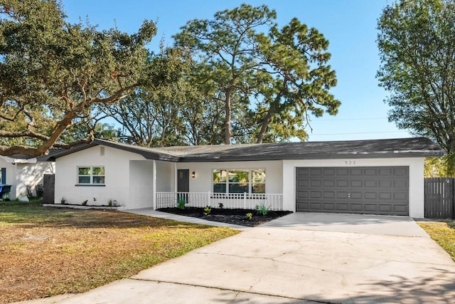 ranch-style home featuring a porch, a garage, and a front lawn