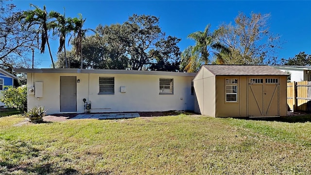 back of property with a lawn and a shed