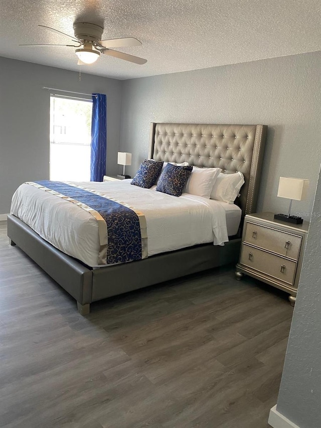 bedroom featuring ceiling fan, dark hardwood / wood-style flooring, and a textured ceiling