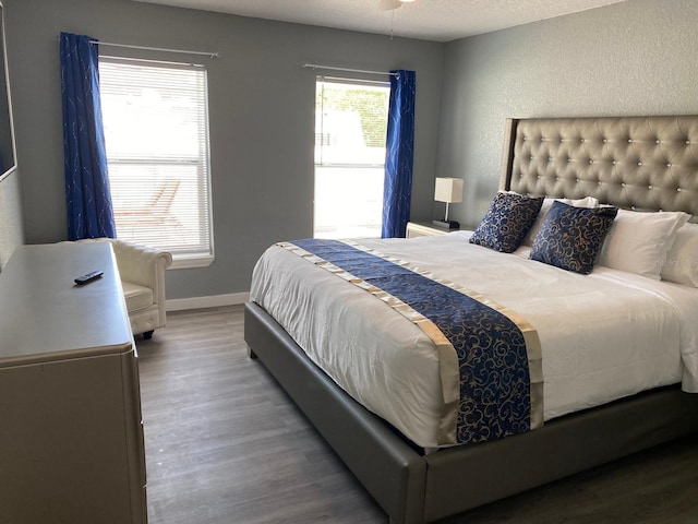 bedroom featuring hardwood / wood-style floors, ceiling fan, and a textured ceiling