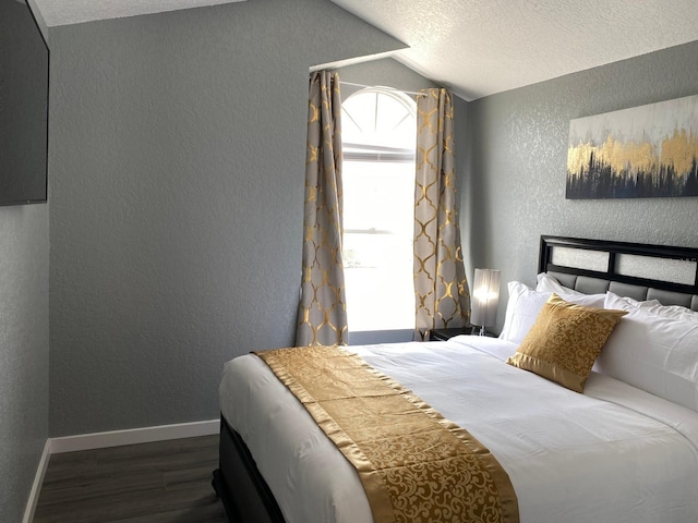 bedroom featuring a textured ceiling, dark wood-type flooring, and vaulted ceiling