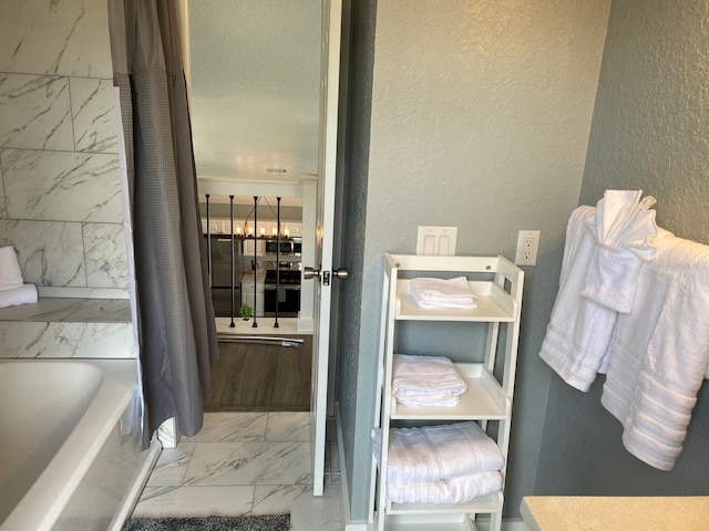 bathroom featuring shower / bathtub combination with curtain and a textured ceiling