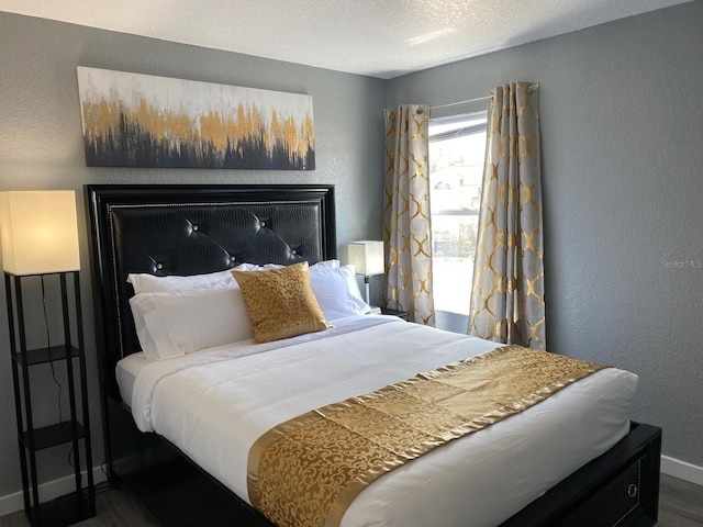 bedroom with a textured ceiling and dark wood-type flooring