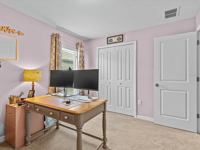 office area featuring light colored carpet and a textured ceiling