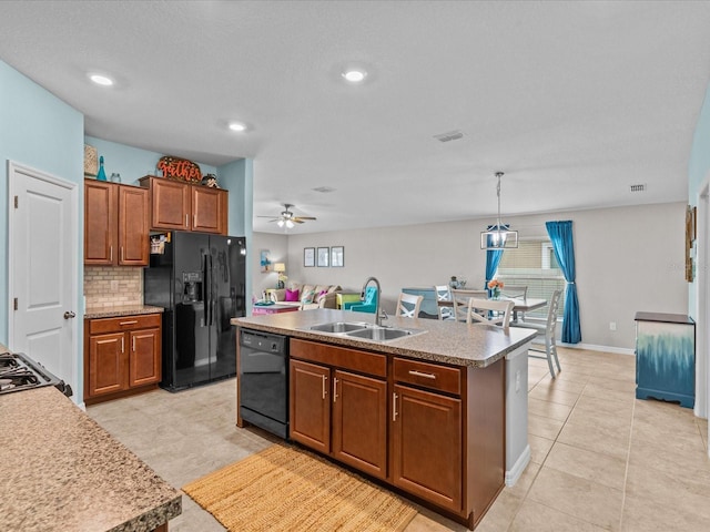 kitchen with pendant lighting, black appliances, a center island with sink, sink, and ceiling fan