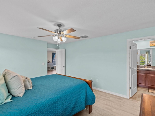 bedroom with ceiling fan, light wood-type flooring, and ensuite bathroom