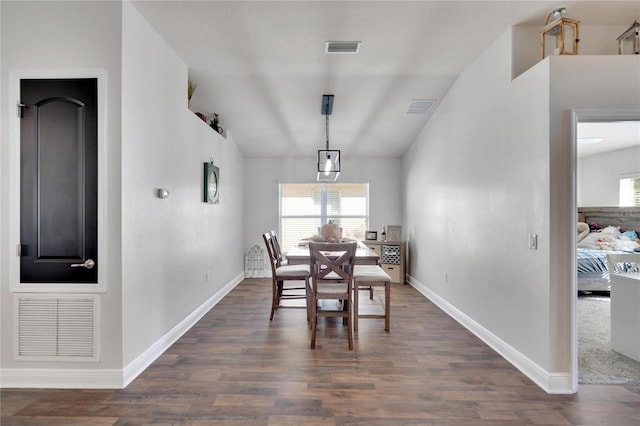 dining room featuring vaulted ceiling and dark wood-type flooring