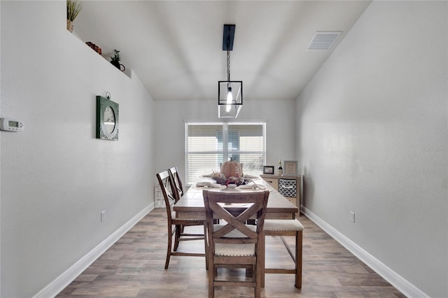 dining room with hardwood / wood-style flooring and lofted ceiling