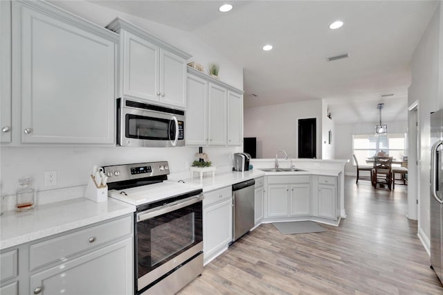 kitchen featuring sink, white cabinets, light wood-type flooring, and appliances with stainless steel finishes