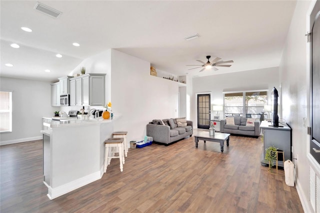 living room featuring vaulted ceiling, ceiling fan, and dark hardwood / wood-style floors