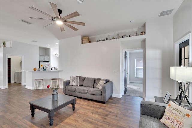 living room with ceiling fan and dark hardwood / wood-style flooring