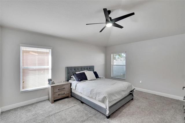 bedroom featuring light colored carpet, vaulted ceiling, and ceiling fan