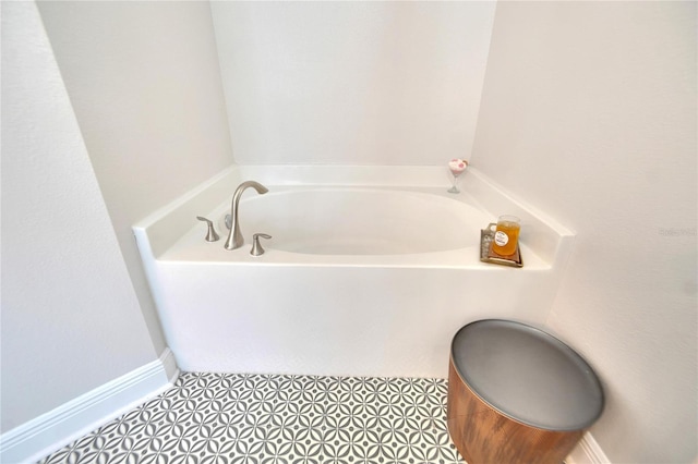 bathroom with a tub to relax in and tile patterned floors