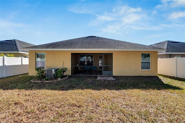 back of property with a lawn and central AC