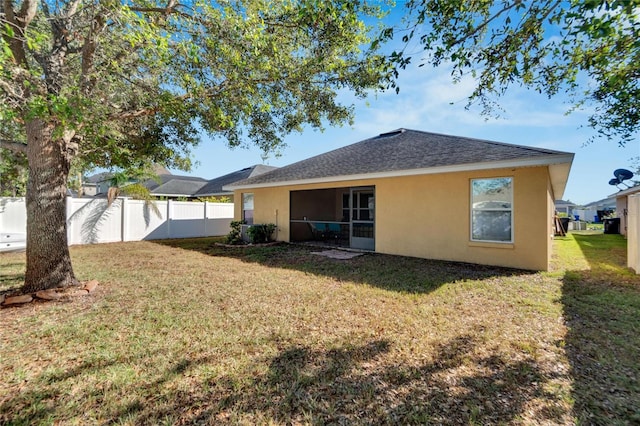 rear view of property featuring a lawn