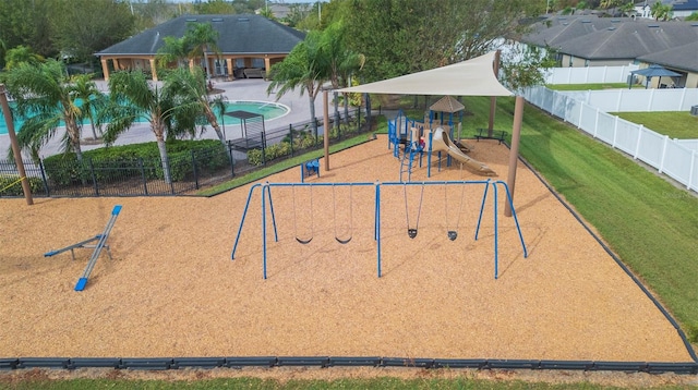 surrounding community featuring a lawn, a playground, and a swimming pool