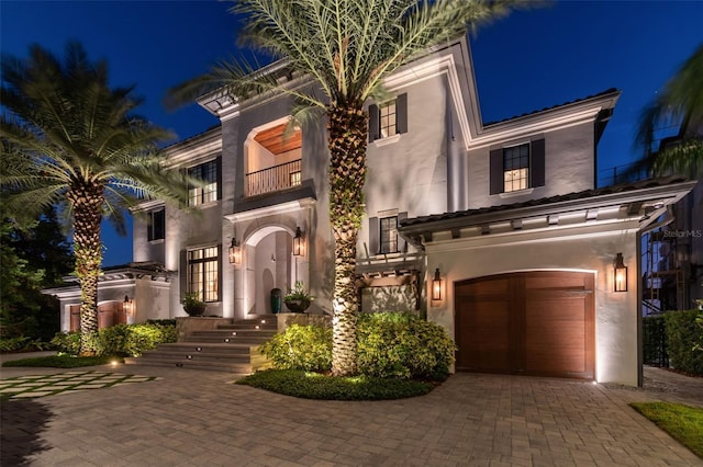 mediterranean / spanish-style home featuring a garage and a balcony