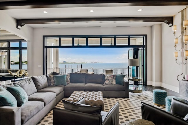 living room featuring beamed ceiling, a water view, and hardwood / wood-style floors