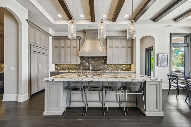 kitchen featuring custom range hood, a spacious island, tasteful backsplash, and pendant lighting