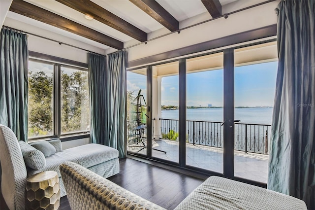 bedroom with access to exterior, beamed ceiling, a water view, and dark wood-type flooring