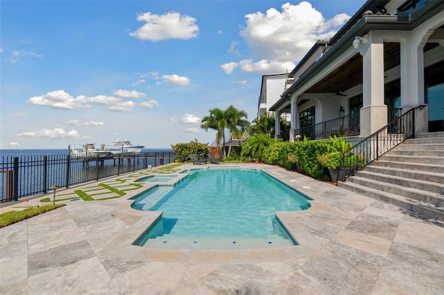 view of swimming pool featuring ceiling fan, a water view, and a patio