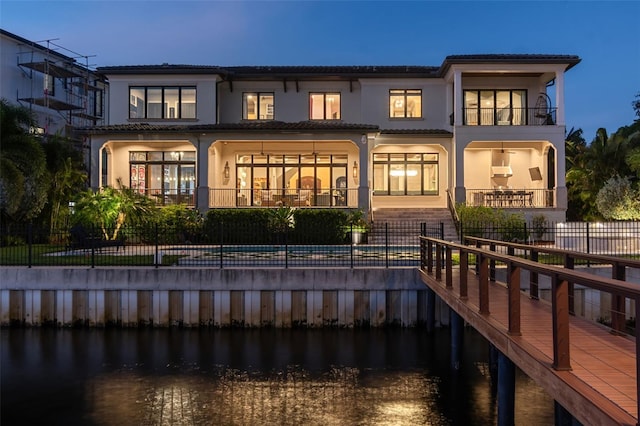 back house at dusk with a water view