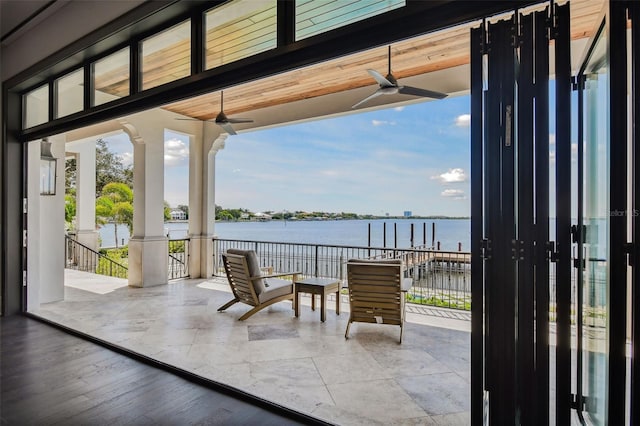 view of patio / terrace with ceiling fan and a water view