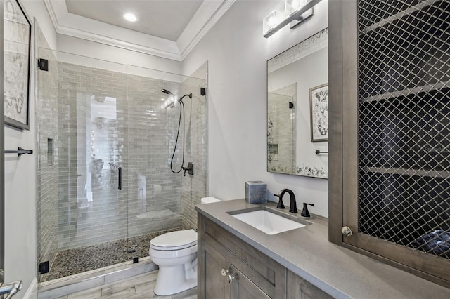 bathroom featuring vanity, hardwood / wood-style flooring, toilet, ornamental molding, and an enclosed shower