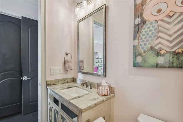 bathroom with hardwood / wood-style floors, vanity, and toilet