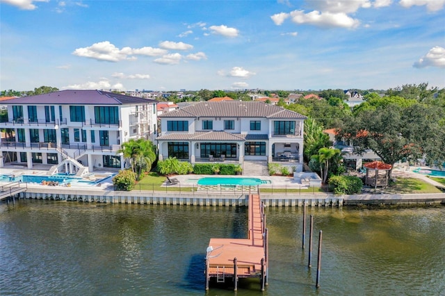 back of property with a patio area, a balcony, and a water view