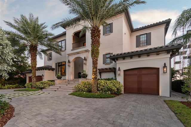 mediterranean / spanish home with a garage and a balcony