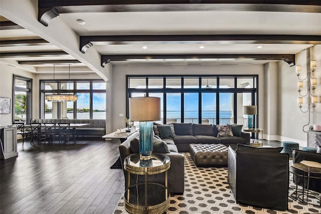 living room featuring beamed ceiling, hardwood / wood-style floors, a water view, and an inviting chandelier