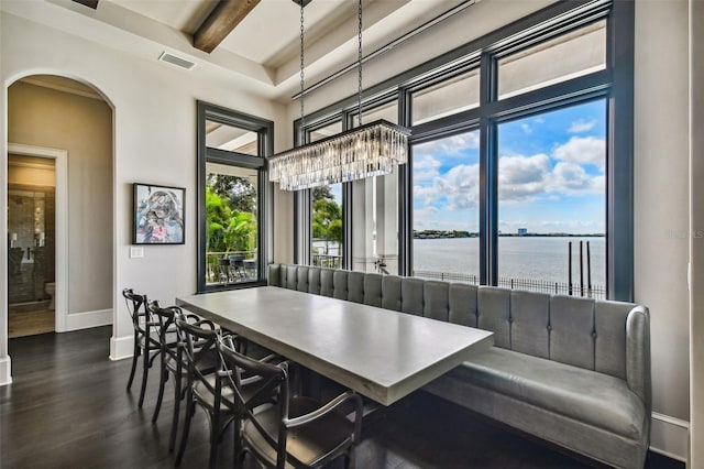5120 W Longfellow Ave, Tampa, FL 33629 - dining area featuring a water view, dark wood-style floors, baseboards, arched walkways, and a towering ceiling