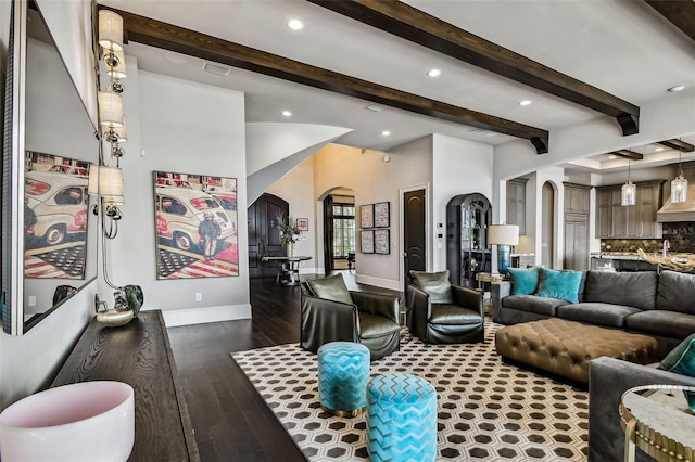 living room featuring sink, beamed ceiling, and dark wood-type flooring