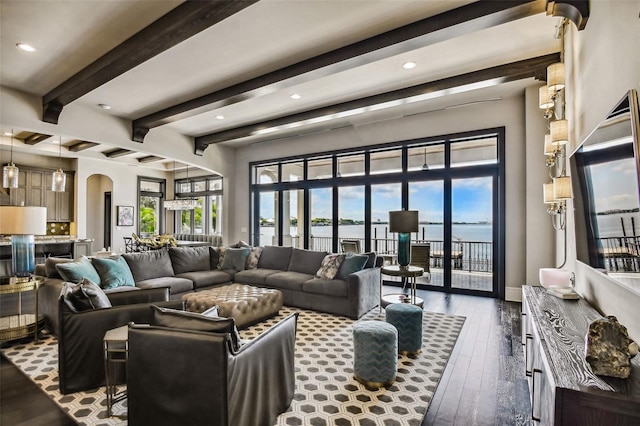 living room featuring beam ceiling, dark hardwood / wood-style flooring, a water view, and french doors