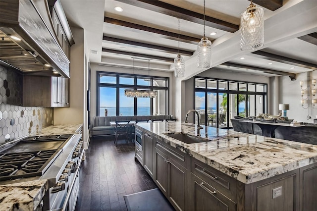 kitchen with a spacious island, a water view, sink, appliances with stainless steel finishes, and custom range hood