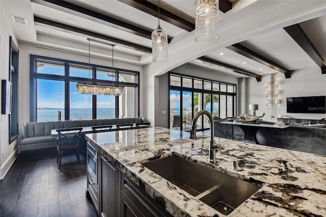 kitchen with pendant lighting, a water view, sink, dark hardwood / wood-style floors, and plenty of natural light