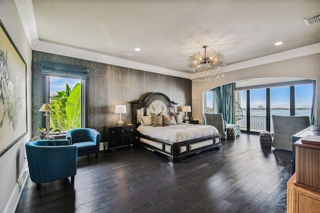 bedroom with multiple windows, dark hardwood / wood-style flooring, a water view, and a notable chandelier