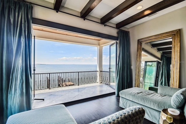 living room with beam ceiling, a water view, and wood-type flooring